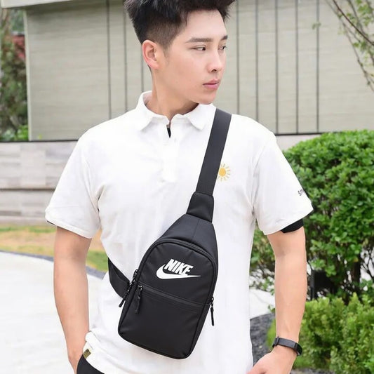 Man wearing a black Nike shoulder bag outdoors